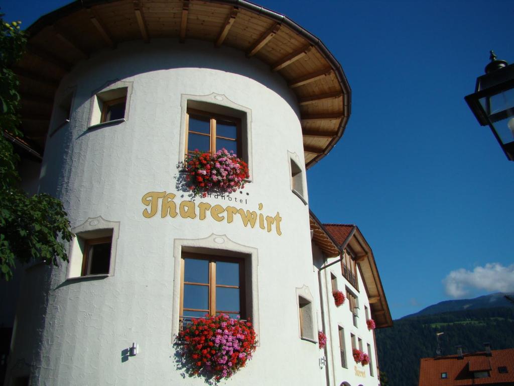 un edificio con flores a un lado. en Landhotel Tharerwirt, en Valdaora