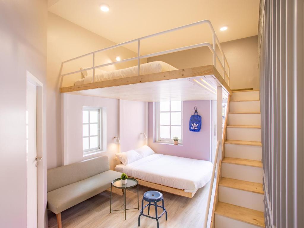 a small bedroom with a bunk bed and stairs at Norn Yaowarat Hotel in Bangkok