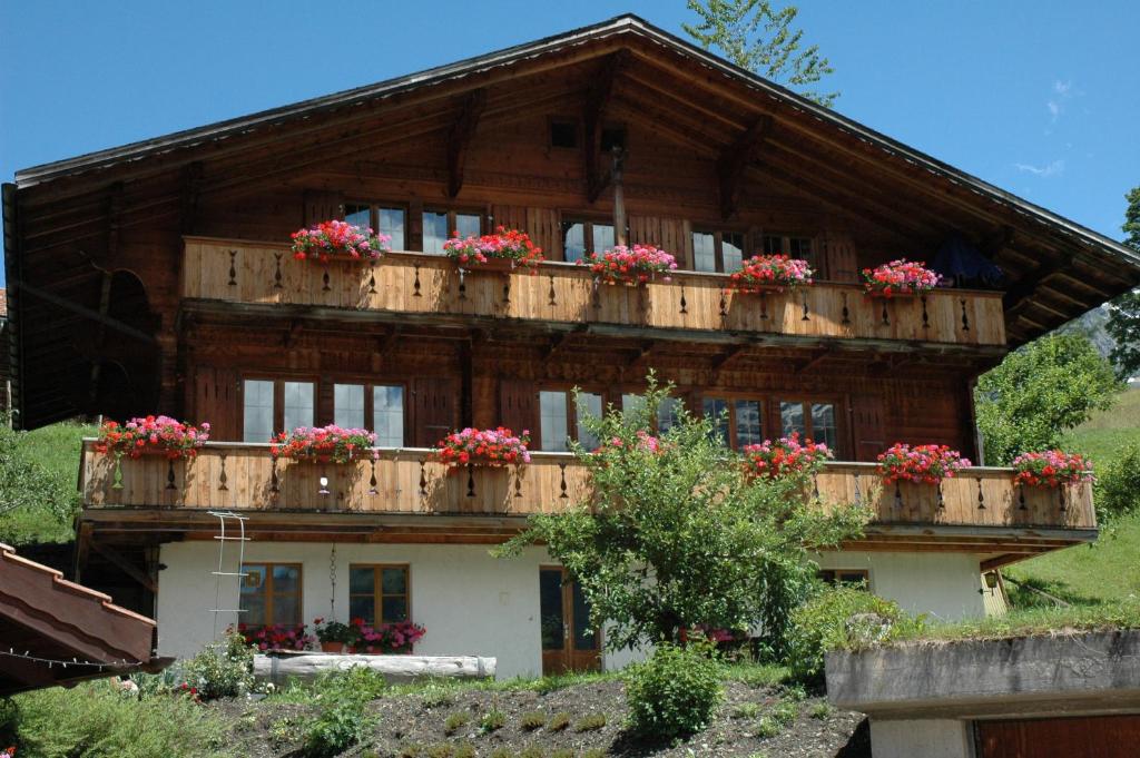 a wooden house with flower boxes on it at Ferienwohnung Uf dr Liwwi in Grindelwald