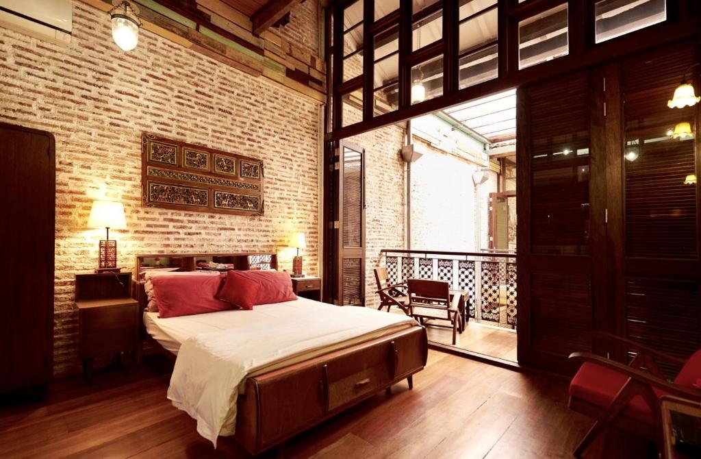 ein Schlafzimmer mit einem großen Bett und einem Balkon in der Unterkunft You Le Yuen in George Town