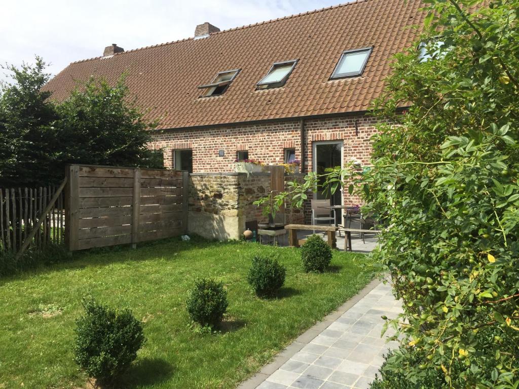 a brick house with a fence and a yard at Luttelkolen in Holsbeek