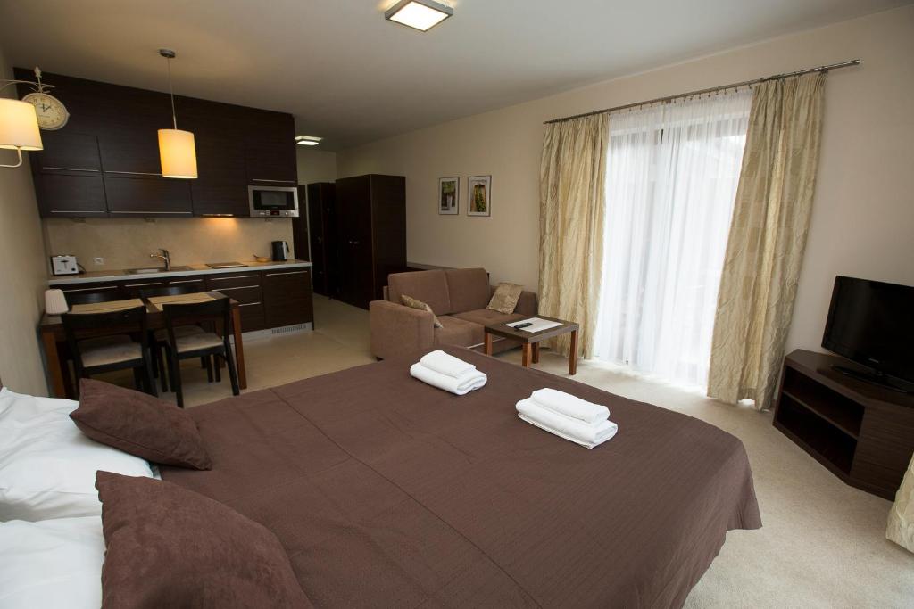 オストルダにあるWilla Port Apartament Liliaのベッドとリビングルームが備わるホテルルームです。
