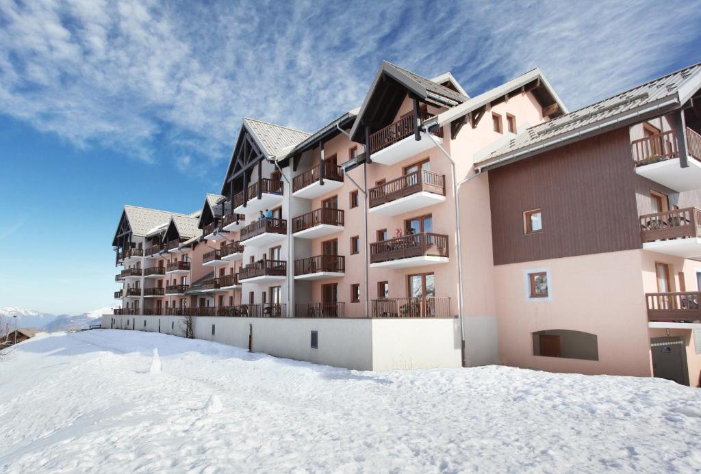 un bâtiment au sommet d'une pente enneigée dans l'établissement Résidence Odalys Les Lumières de Neige, à Valmeinier