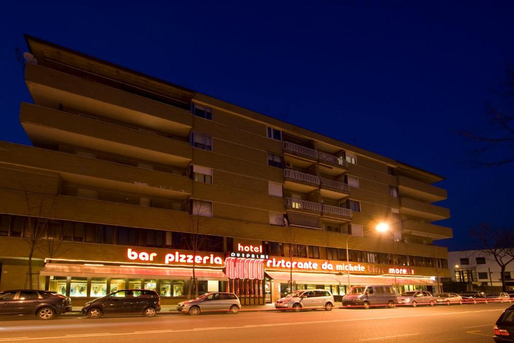 un edificio con coches estacionados fuera de él por la noche en Hotel Alle Due Palme, en Udine