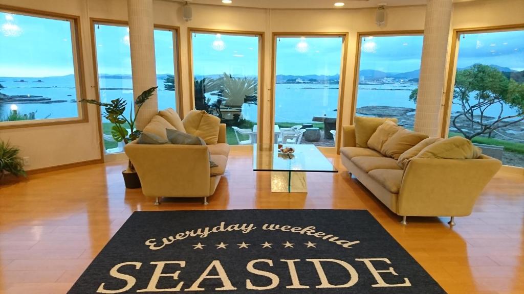 a living room with two couches and a sashide sign at Shirahama Seaside Villa in Tanabe