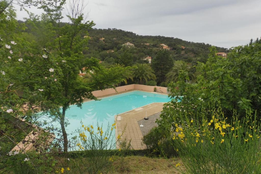 een blauw zwembad met een heuvel op de achtergrond bij Residence La Source in Le Boulou