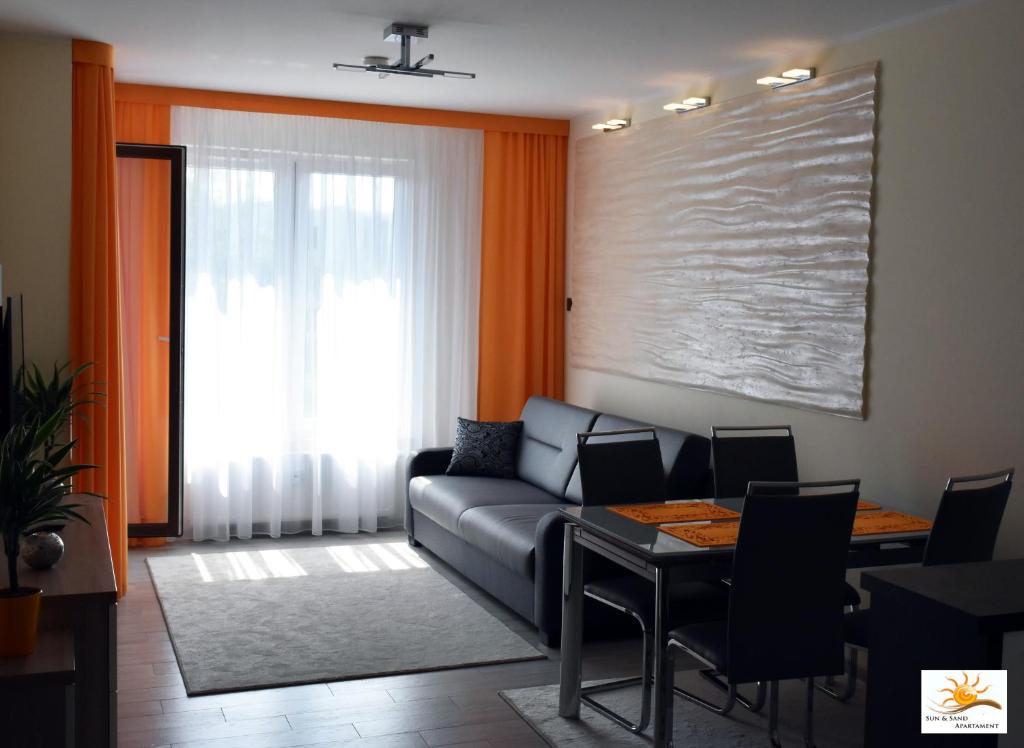a living room with a couch and a table at Apartament Sun & Sand Polanki in Kołobrzeg