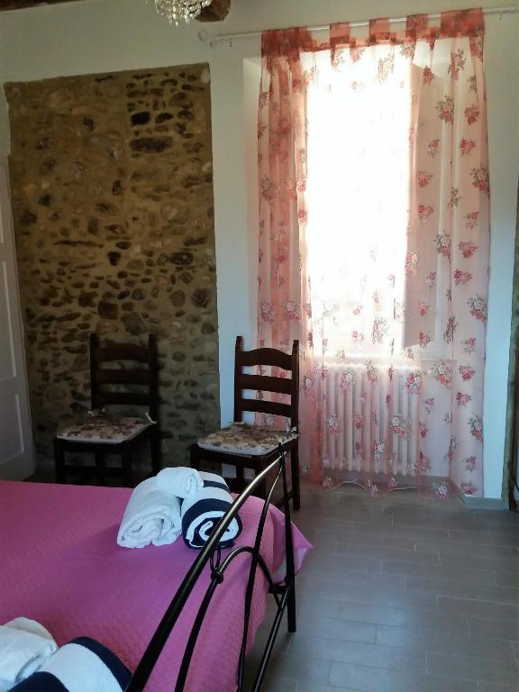 a bedroom with a bed and two chairs and a window at IL PRINCIPINO B&B in Massa