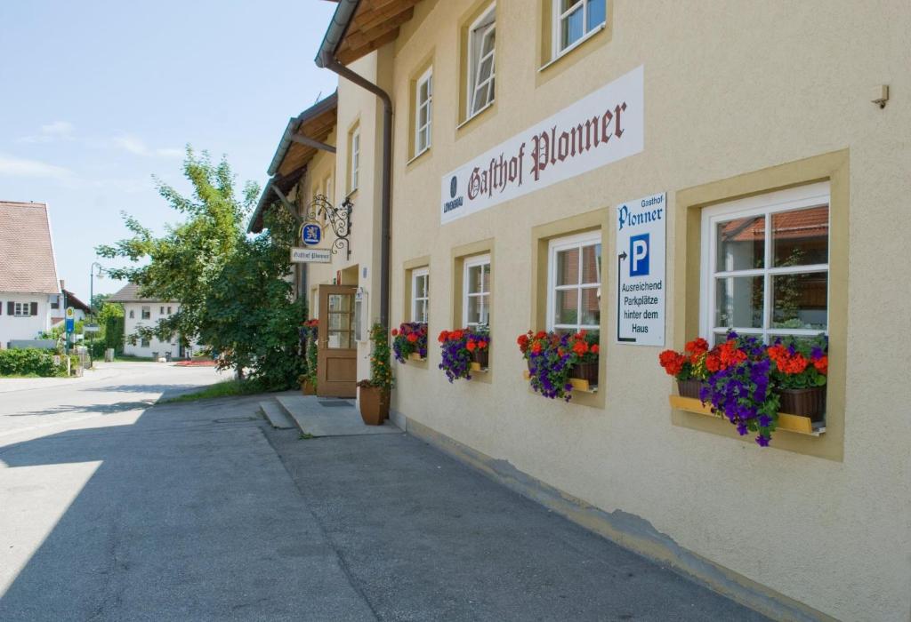 un bâtiment avec des boîtes de fleurs sur son côté dans l'établissement Il Plonner - Hotel Restaurant Biergarten, à Weßling