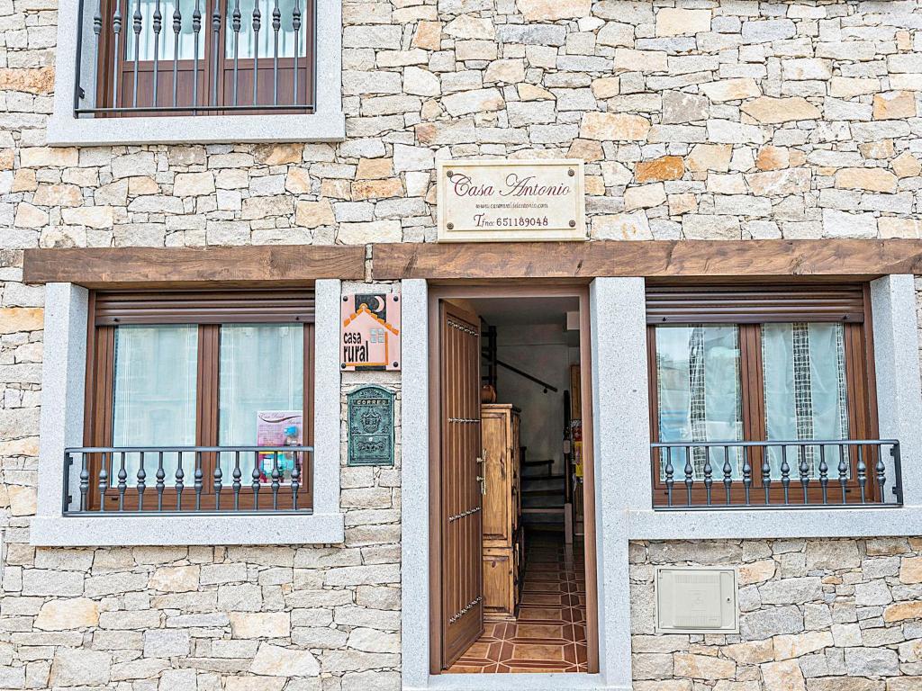 a building with two windows and a sign on it at Casa Rural Antonio in Vitigudino