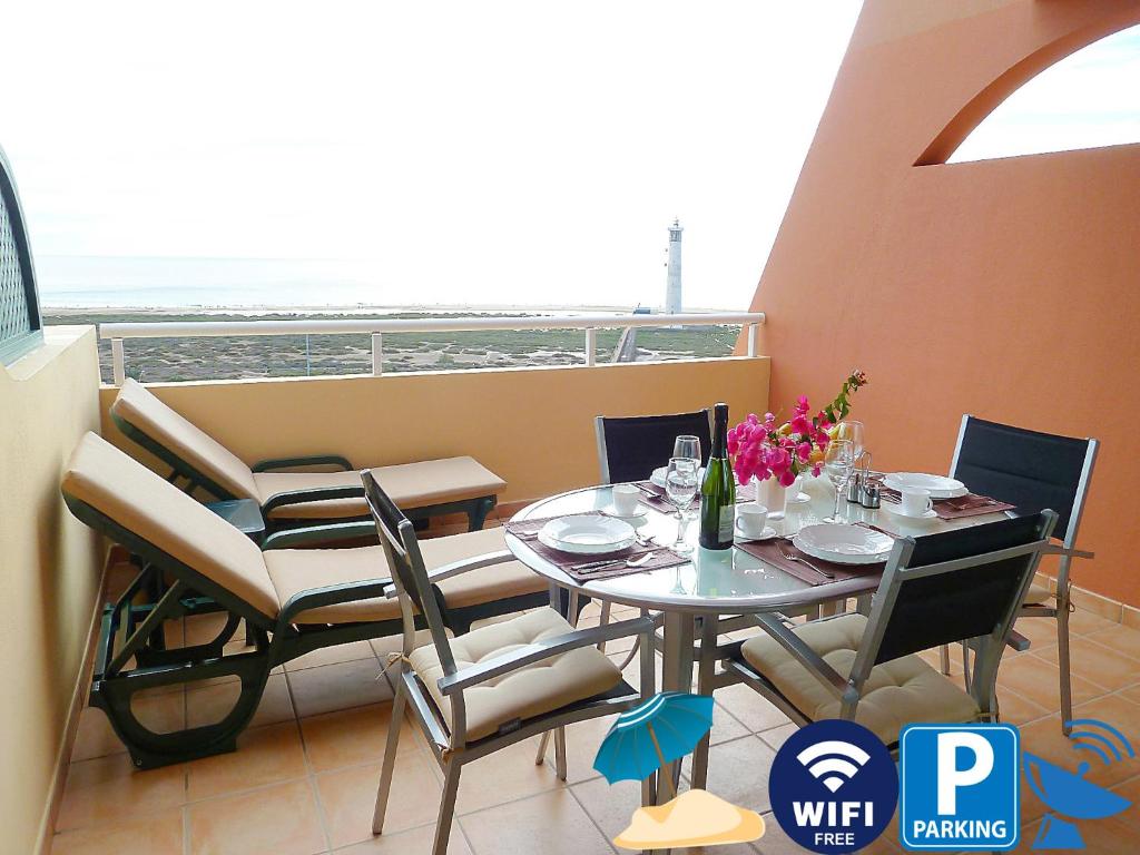 a dining room with a table and chairs and a balcony at Luxury Apartment Balcon de Jandía in Morro del Jable