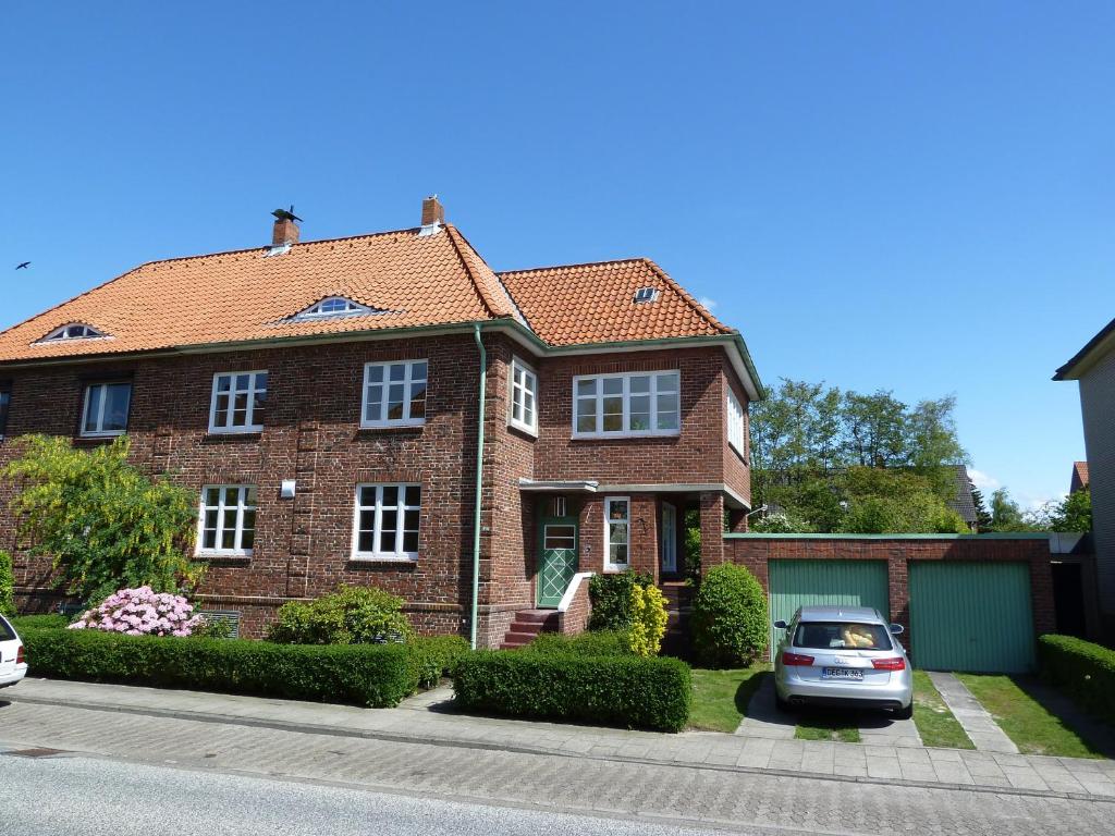 ceglany dom z samochodem zaparkowanym przed nim w obiekcie Ferienhaus Kugelbake w mieście Cuxhaven