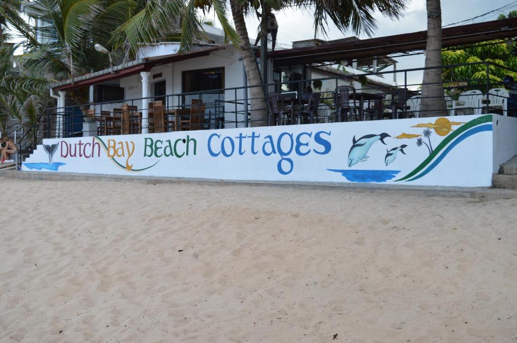 a sign on the beach in front of a resort at Dutch Bay Beach Cottages in Trincomalee