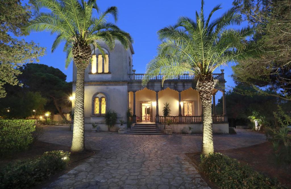 une maison avec deux palmiers devant elle dans l'établissement Villa Scinata Dimora Storica, à Nardò