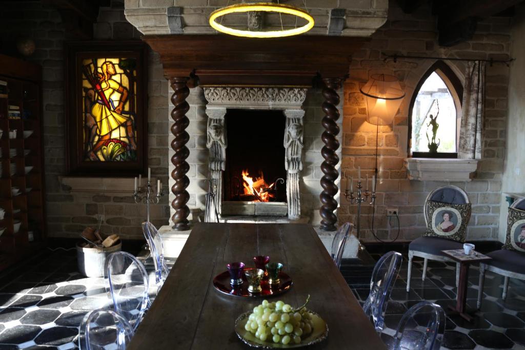 een eetkamer met een tafel en een open haard bij Trumpet House in Leuven