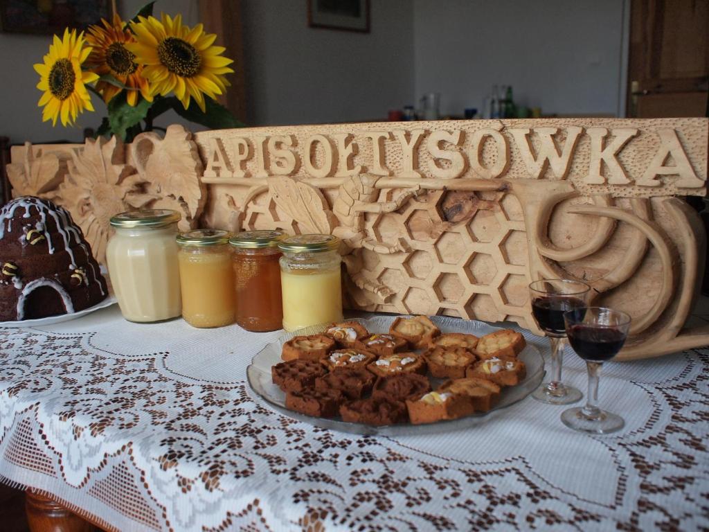 a table with a plate of food and glasses of wine at Apisoltysowka in Powązki