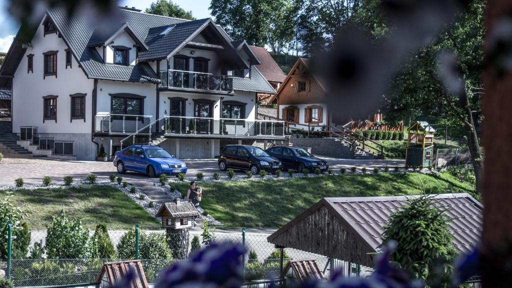 una casa con coches aparcados delante de ella en Zajazd Nad Stawem en Grabówko