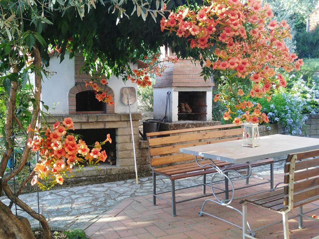 una mesa y un banco con horno de pizza en Casa di Giulia (Bambini gratis fino a 6 anni), en Santa Luce