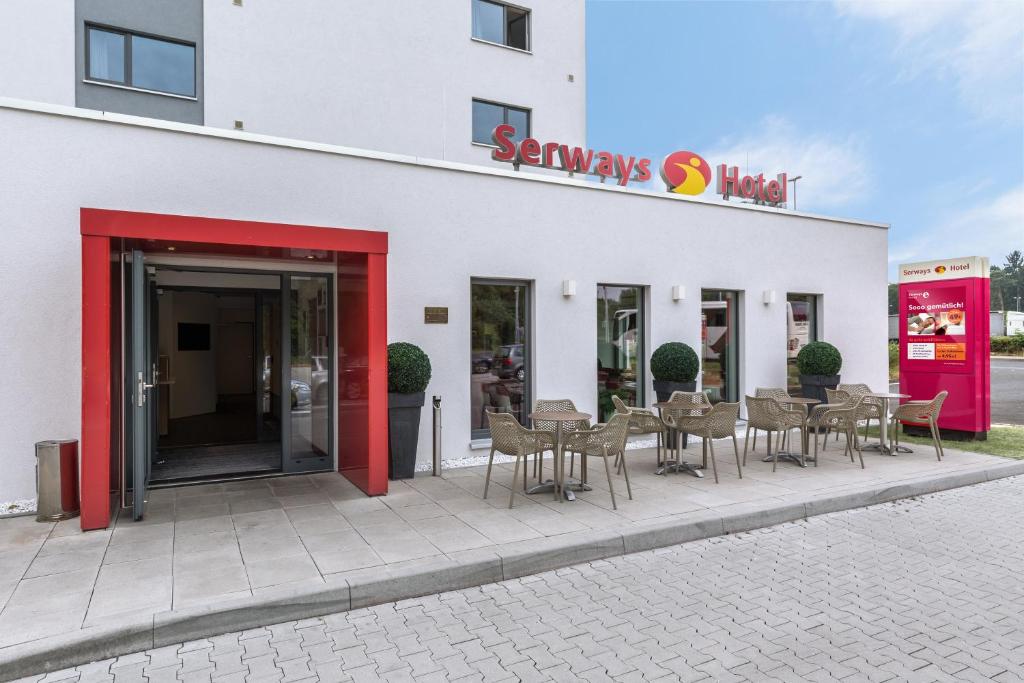 a group of chairs and tables outside of a store at Serways Hotel Weiskirchen Nord in Rodgau