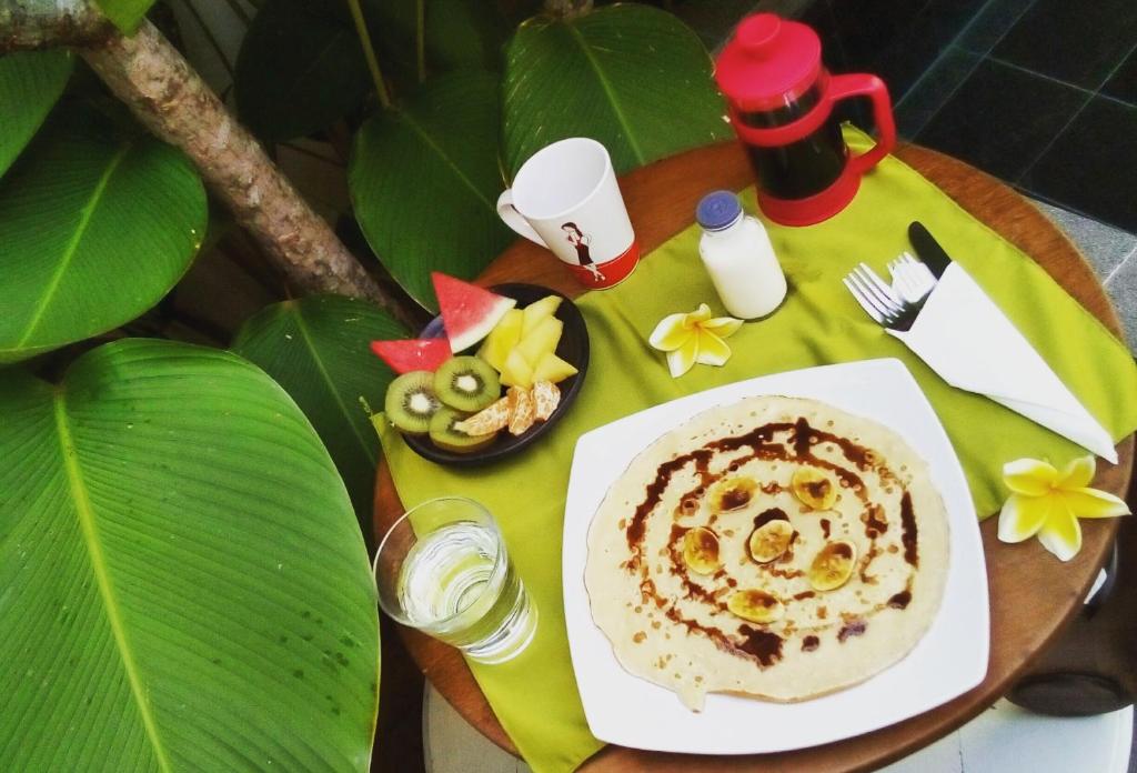 a table with a plate of food on a table at The Patio Yogya in Yogyakarta