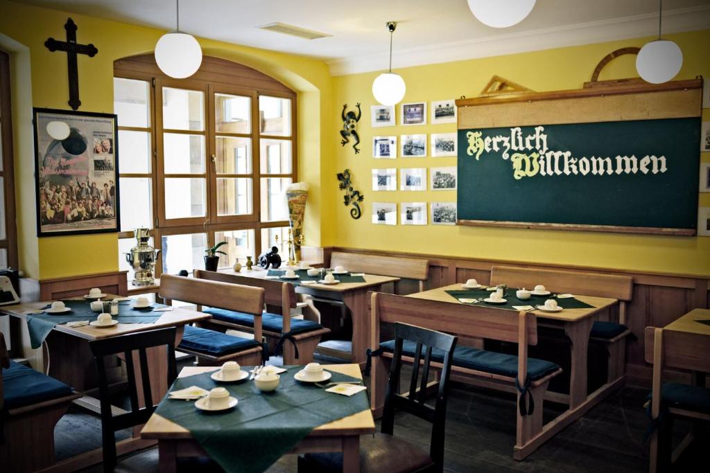 a restaurant with wooden tables and chairs and a chalkboard at Altstadthotel Haßfurt GbR in Haßfurt