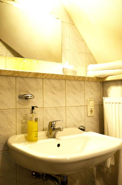 a bathroom sink with a yellow soap bottle on it at Altstadthotel Haßfurt GbR in Haßfurt