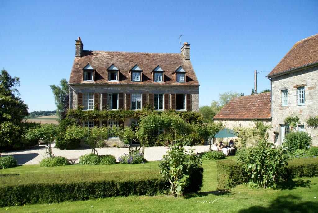 een oud huis met een tuin ervoor bij Chambres d'Hôtes Belle Vallee in Domfront