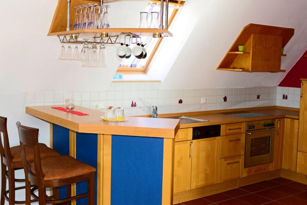a kitchen with wooden cabinets and a blue island at Altstadthotel Haßfurt GbR in Haßfurt