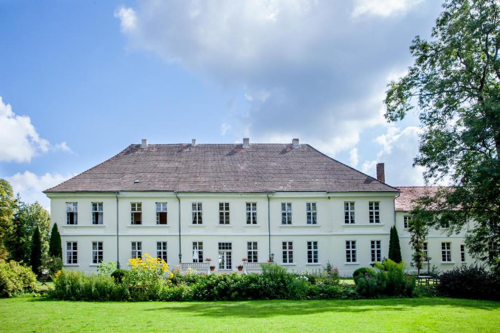a large white house with a gray roof at Herrenhaus Samow in Behren-Lübchin