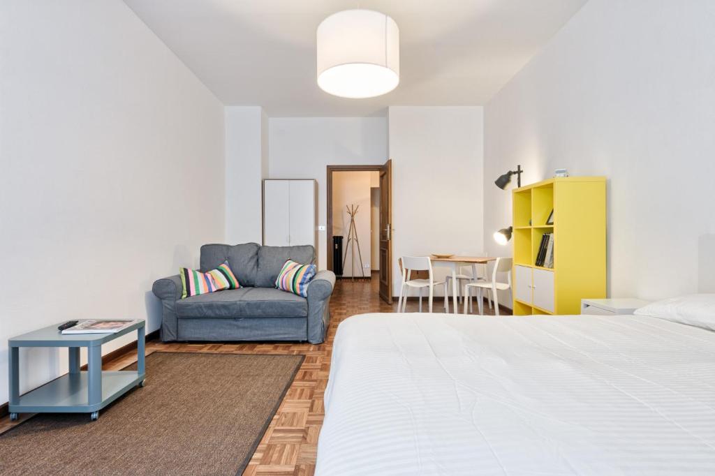 ein Schlafzimmer mit einem Bett, einem Sofa und einem Tisch in der Unterkunft Porta Nuova Shiny Studio Flat in Turin