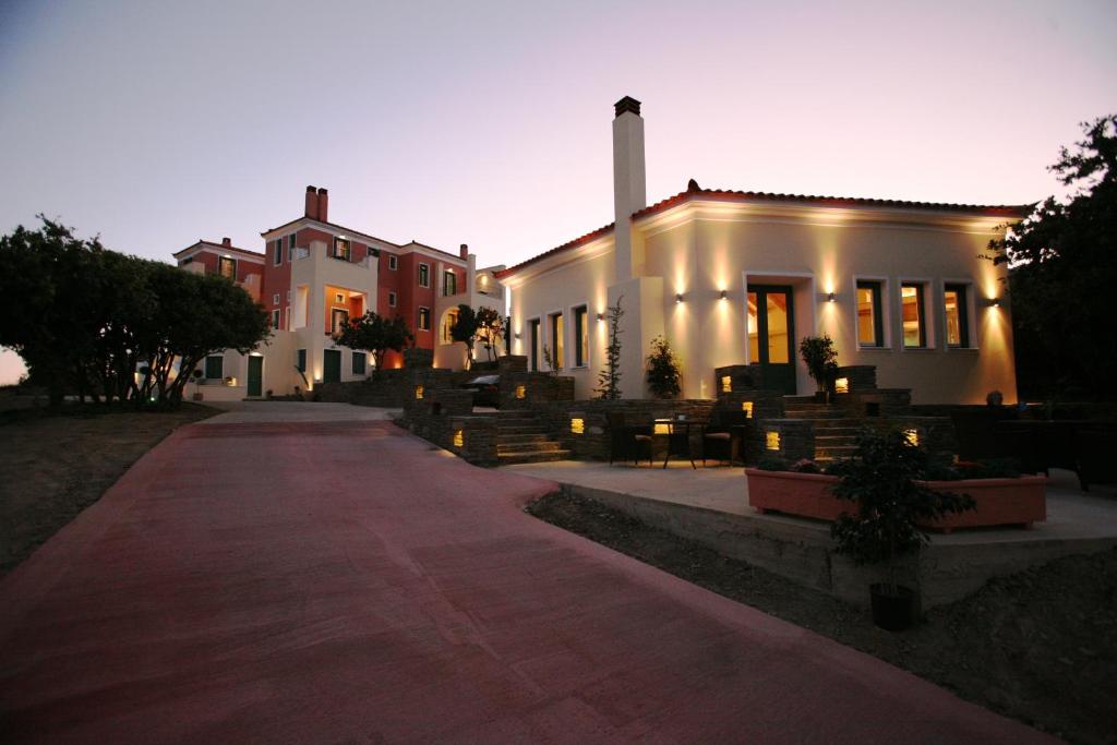 un grand bâtiment blanc avec un sentier devant lui dans l'établissement Armonia Resort, à Ménites