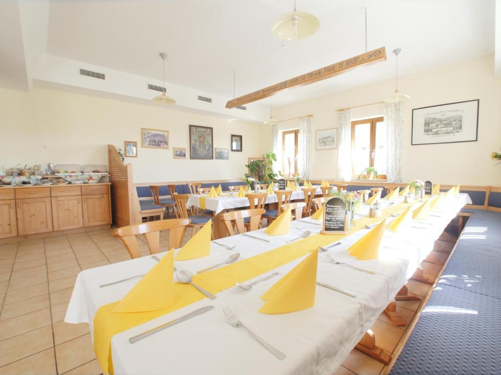 eine Reihe von Tischen und Stühlen in einem Restaurant in der Unterkunft Wirtshaus Zur Bina in Vilsbiburg
