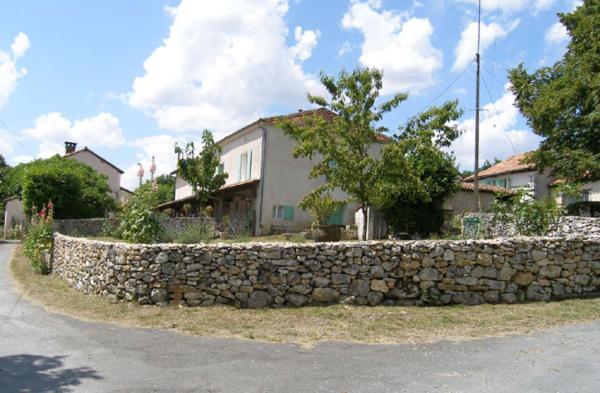 Cercles的住宿－Gite paisible a la Roche，房屋前的石墙