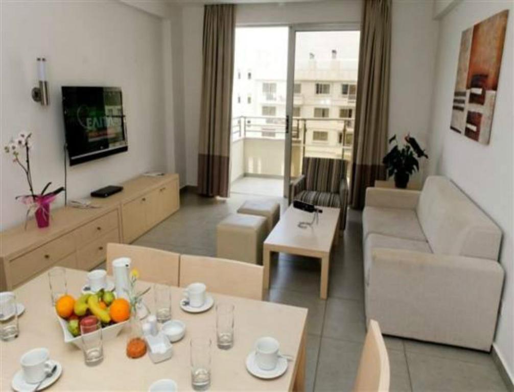 a living room with a table with fruit on it at Capital Coast Resort And Spa in Paphos