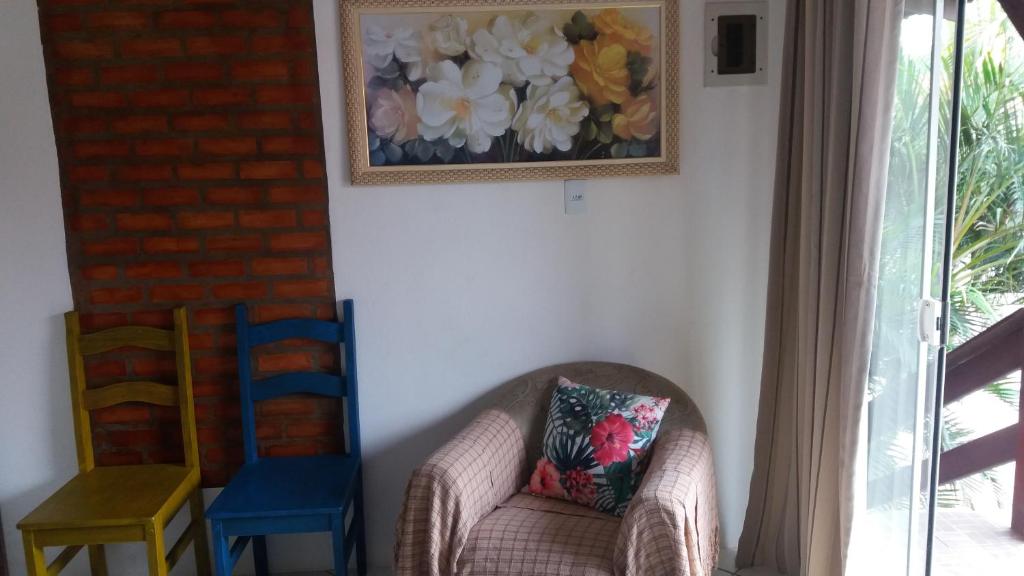 una sala de estar con 2 sillas y una foto en la pared en Apart Luis, en Penha