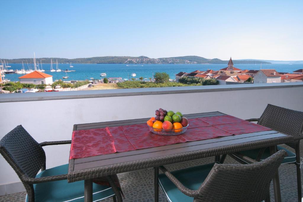una mesa con un bol de fruta en el balcón en Apartments Daniela, en Trogir