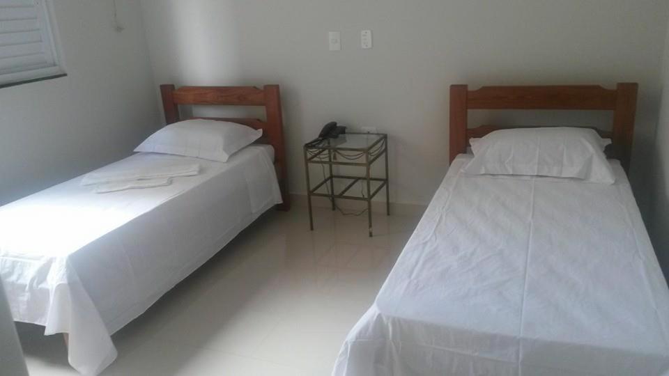 dos camas sentadas una al lado de la otra en una habitación en Arym Hotel, en Aparecida do Taboado