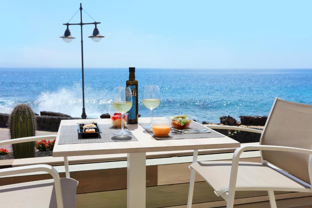 a table with a bottle of wine and two glasses at Iberostar Selection Lanzarote Park in Playa Blanca