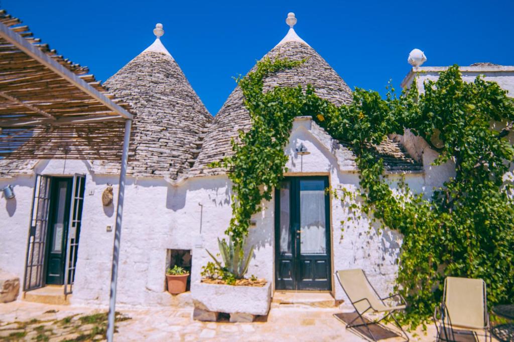 a house with vines growing on the side of it at Masseria Rosa Trulli Relais in Alberobello