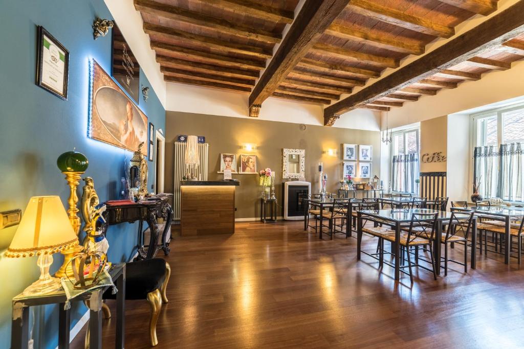 Domus San Martino GuestHouse في بياتشينزا: غرفة طعام مع طاولات وكراسي وجدران زرقاء