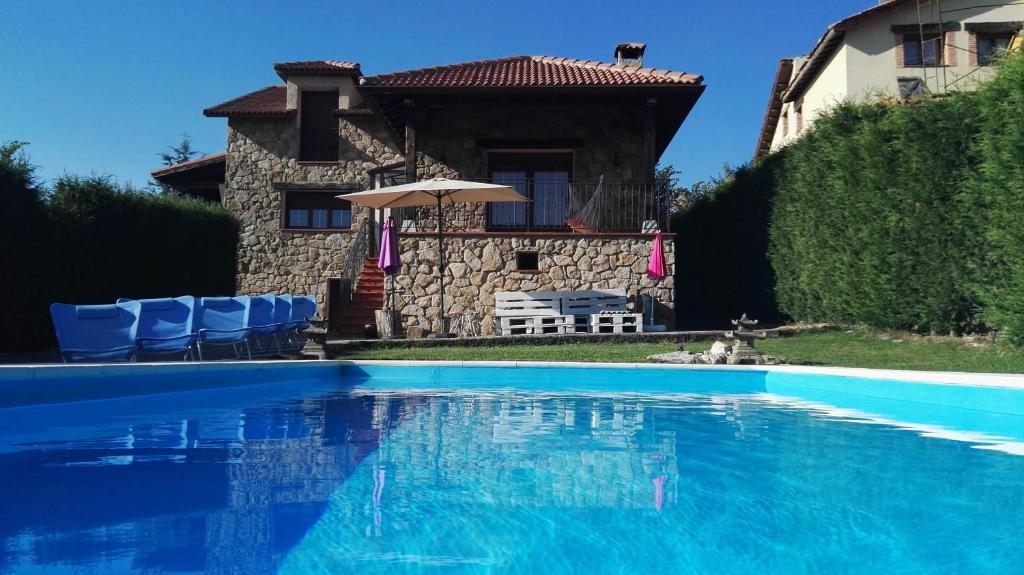 a swimming pool in front of a house at Casa El balcón de Iria in Otero de Herreros