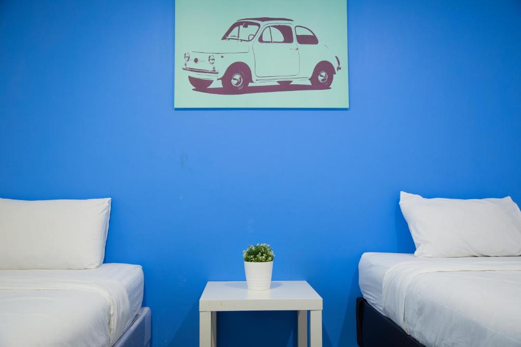 um quarto azul com 2 camas e uma parede azul em Varinda Hostel em Bangkok