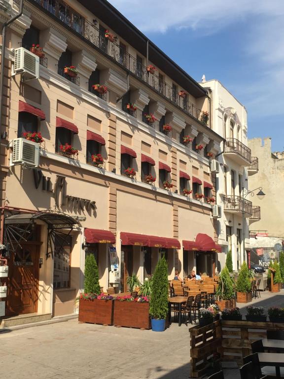 un edificio con mesas y sillas delante de él en Villa Anticus (Adults Only), en Constanţa