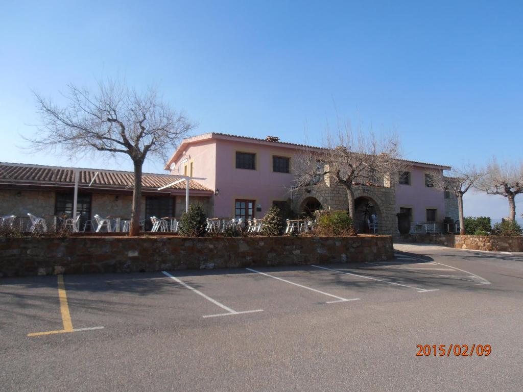 Vall dʼAlba的住宿－勒爾米塔卡薩里波酒店，前面有停车位的大楼