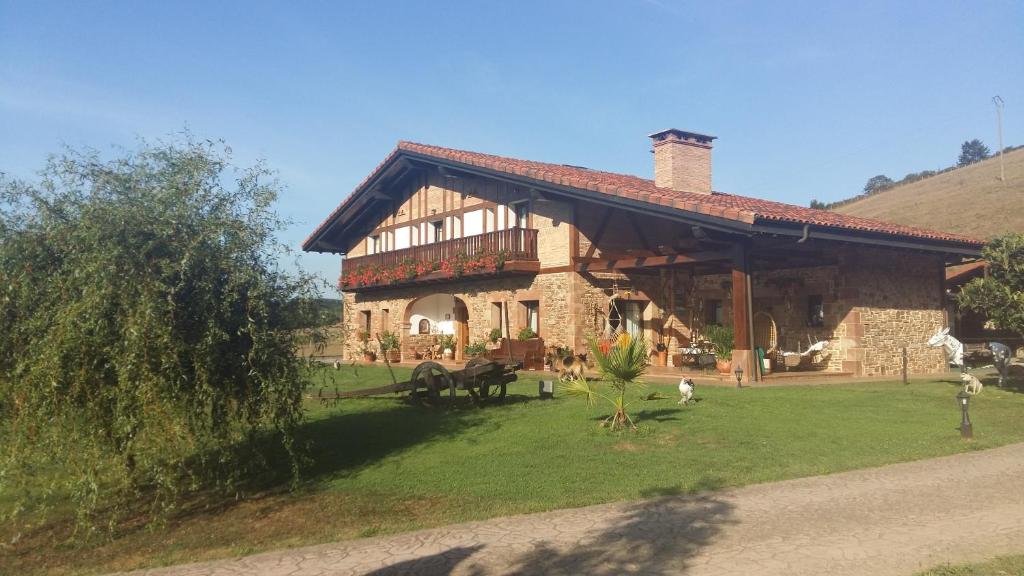 una casa grande con un patio de hierba delante de ella en Lezamakoetxe, en Sopuerta