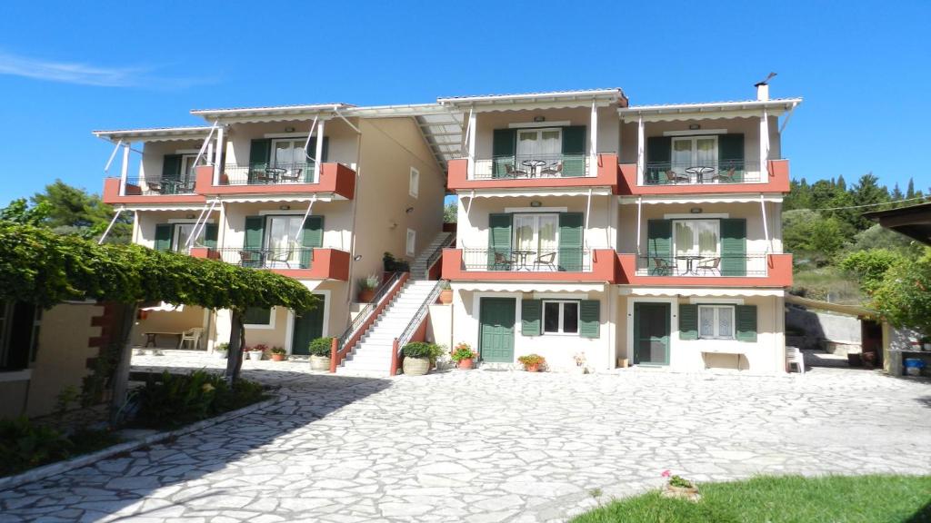 ein großes Apartmenthaus mit einer Auffahrt davor in der Unterkunft Filoxenia Kontogiannis in Lazaráta