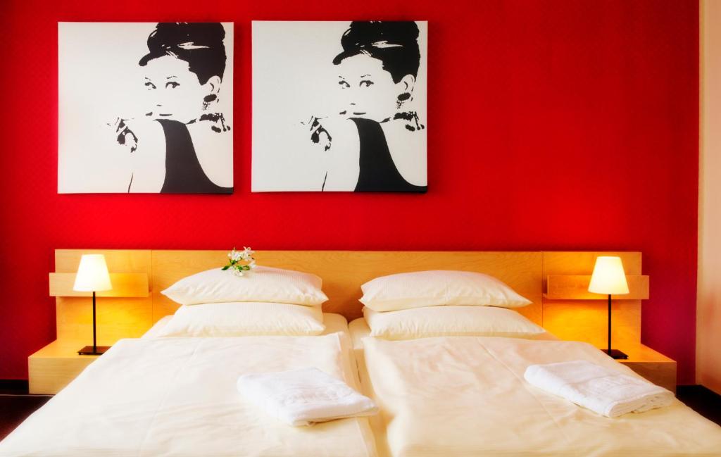 a bedroom with two beds and a red wall at Cityherberge in Dresden