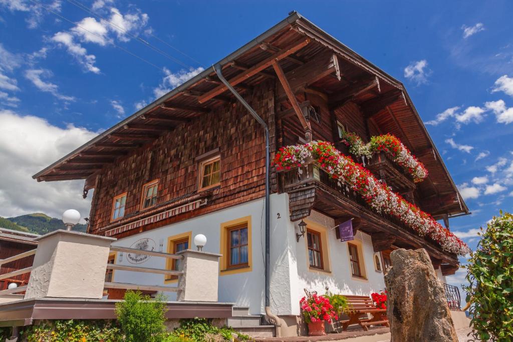 una casa con flores a un lado. en Spielbichlhof, en Mittersill