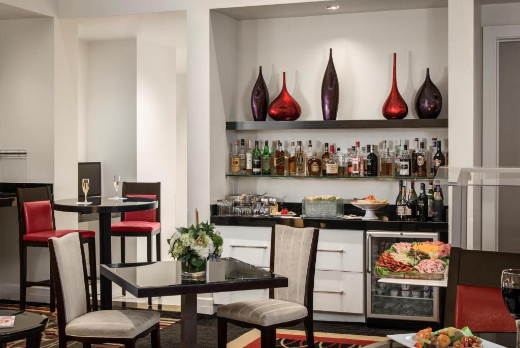 a restaurant with tables and chairs and vases on the wall at Inn On Fifth in Naples