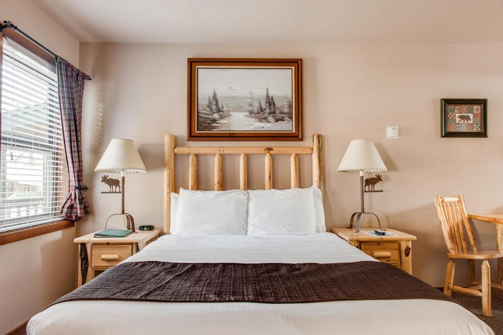 ein Schlafzimmer mit einem Bett, zwei Tischen und zwei Lampen in der Unterkunft Franciscan Lodge in Tahoe Vista